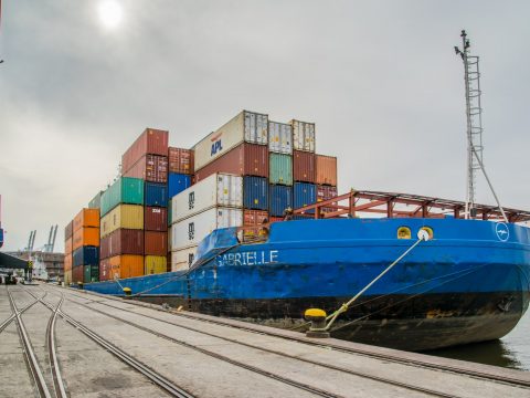 blue and red cargo ship on dock during daytime